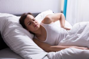 Woman resting in bed, suffering from back pain
